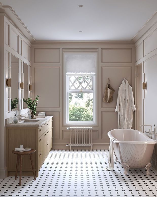 Elegant traditional bathroom with a freestanding clawfoot bathtub, wall-mounted basin vanity, large framed mirror, decorative wall panelling, ornate mouldings, a central window, and a patterned monochrome tiled floor. The room has a refined, softly neutral palette with warm timber cabinetry and brass-toned hardware.