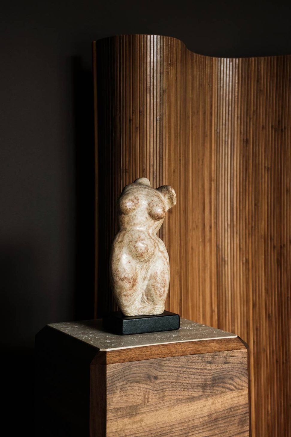 imgi6antique-stone-woman-sculpture-on-wooden-pedestal-in-moody-modern-interior-design.jpg