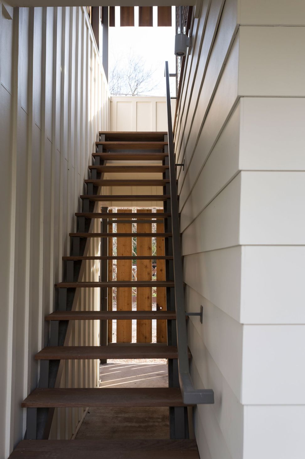 07BackAlleyCuppettKilpatrickArchitectureandInteriorDesignaustin-tx-guesthouse-staircase-metal-handrail-cedar-privacy-screen-1.jpg