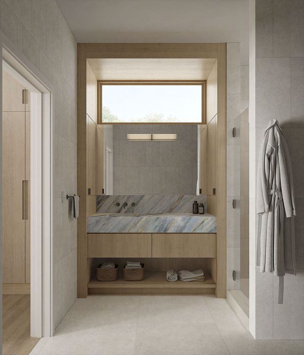 A refined contemporary bathroom with a walk-in shower at the rear, framed by warm timber-look joinery and a large horizontal window. The room features pale large-format wall and floor tiles, a grey-blue veined stone vanity benchtop with integrated basin, timber vanity drawers and open shelving, wall-mounted lighting, and a robe hanging on the right. A timber-floored adjoining space is visible through the doorway on the left.