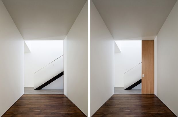 A minimalist interior hallway or landing with dark timber flooring, smooth white walls and ceiling, and a stairwell visible at the far end. The paired view highlights a tall timber-lined door or joinery panel on the right side in one image. The space is sharply geometric, uncluttered, and softly lit.